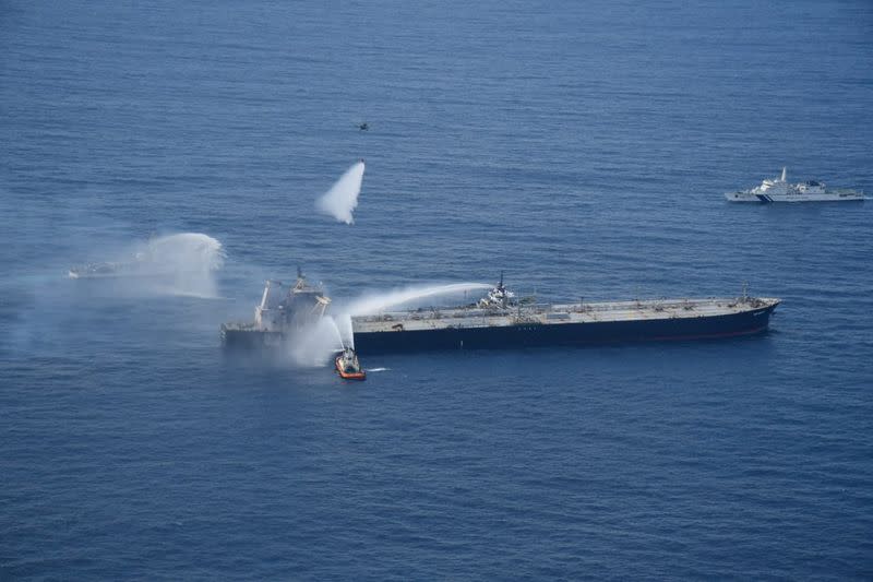 A Sri Lankan Navy boat sprays water on the New Diamond, a very large crude carrier (VLCC) chartered by Indian Oil Corp (IOC), that was carrying the equivalent of about 2 million barrels of oil, after a fire broke out off east coast of Sri Lanka