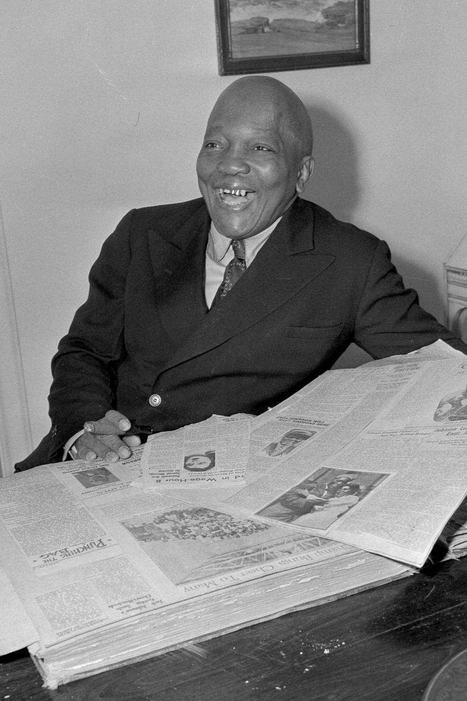 Jack Johnson looks through a scrapbook of newspaper clippings in Los Angeles in 1943 Photo: AP Photo/John T. Burns