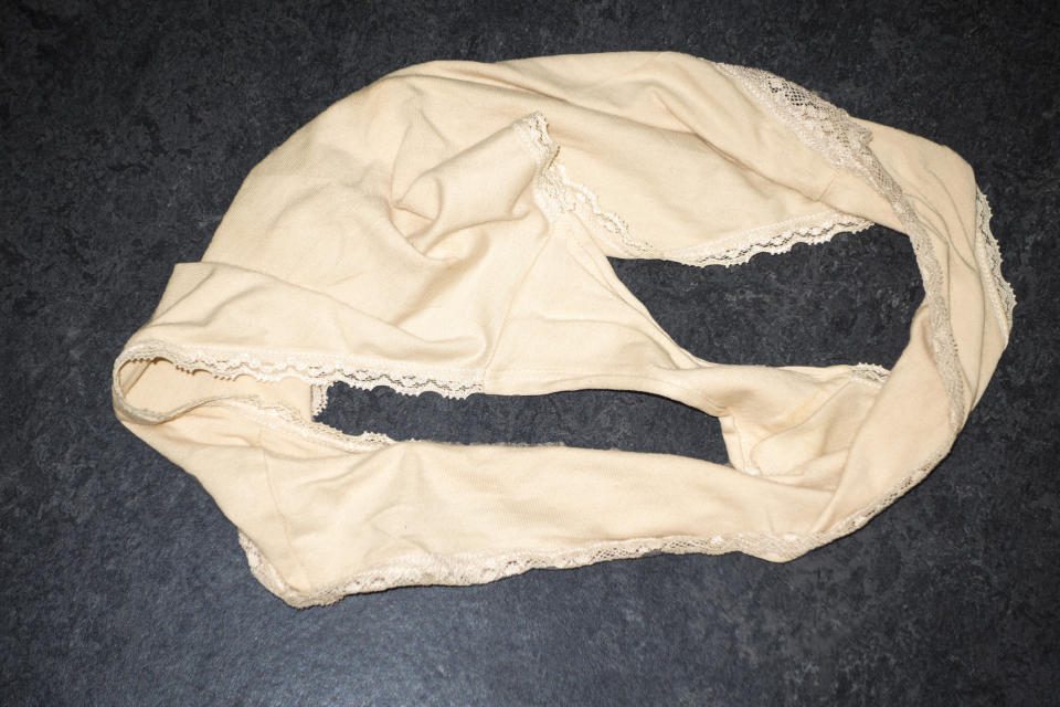 A pair of beige underwear with lace trim, displayed flat