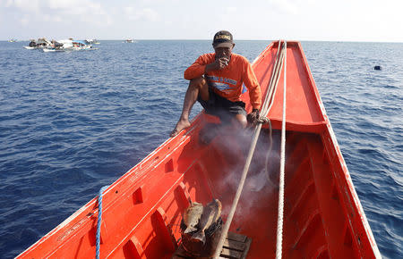 A Filipino fisherman cooks fish on a fishing boat at the disputed Scarborough Shoal April 6, 2017. Picture taken April 6, 2017 REUTERS/Erik De Castro