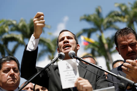 Juan Guaido, President of Venezuela's National Assembly, holds a copy of the National Constitution while he speaks during a news conference in Caracas, Venezuela January 21, 2019. REUTERS/Manaure Quintero