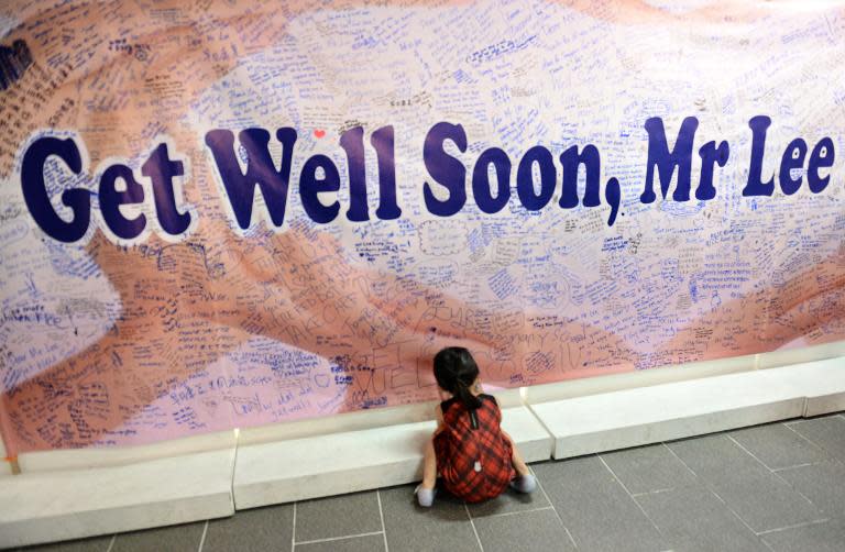 A girl writes a well-wishing message on a board at the Tanjong Pagar community centre in Singapore on March 22, 2015