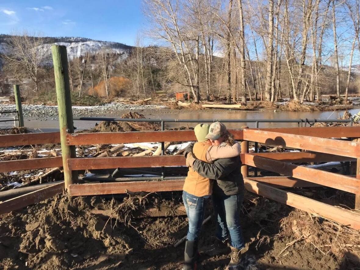 Rhonda MacDonald, right, embraces her friend at Bar FX Ranch in Merritt, B.C., which was washed out in November by floods from the nearby Nicola River. (Julia Smith - image credit)