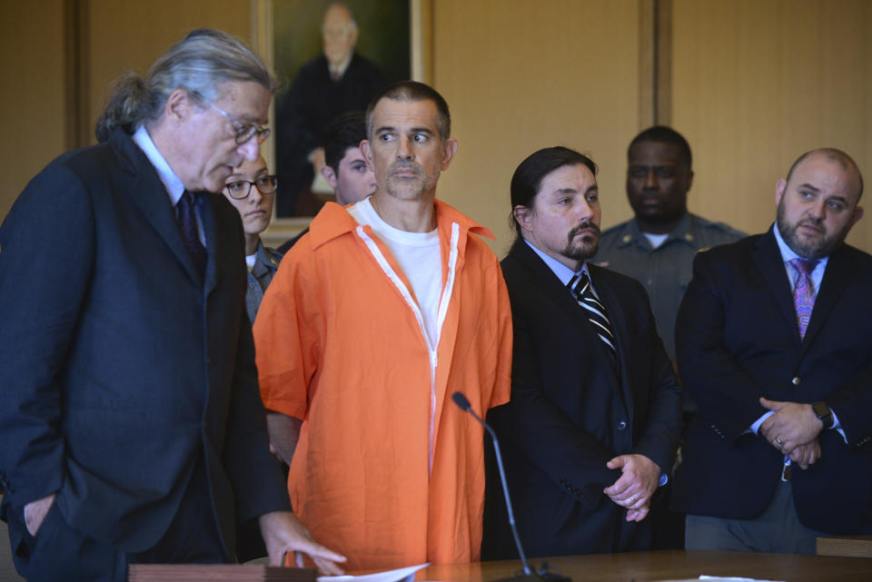 Fotis Dulos, center, listens, as his attorney Norm Pattis, left, addresses the court during a hearing at Stamford Superior Court, Tuesday, June 11, 2019 in Stamford, Conn. Fotis Dulos, and his girlfriend, Michelle Troconis, have been charged with evidence tampering and hindering prosecution in the disappearance of his wife Jennifer Dulos. The mother of five has has been missing since May 24. (Erik Trautmann/Hearst Connecticut Media via AP, Pool)