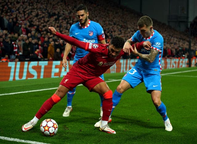 Alex Oxlade-Chamberlain holds off two Atletico Madrid players