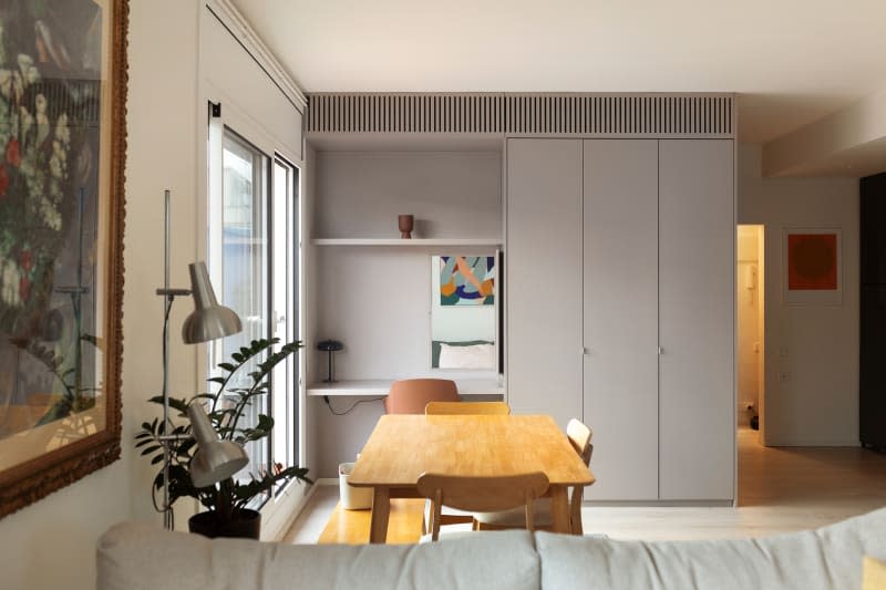 Built-in desk and closet across from a wooden dining table.