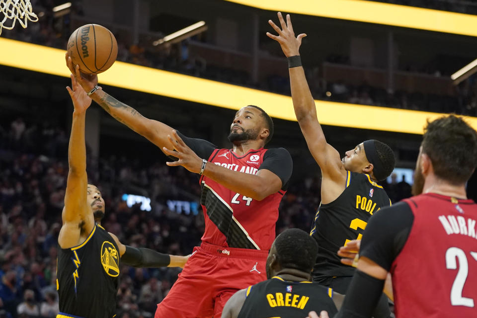 Portland Trail Blazers forward Norman Powell, center, shoots against Golden State Warriors forward Otto Porter Jr., left, forward Draymond Green, bottom, and guard Jordan Poole during the first half of an NBA basketball game in San Francisco, Friday, Nov. 26, 2021. (AP Photo/Jeff Chiu)