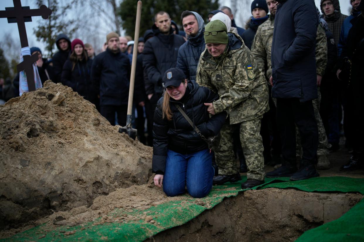 Anna Korostenska, 24, drops to her knees before the grave of her fiancee Oleksii Zavadskyi, a Ukrainian serviceman who died in combat on 15 January (AP)