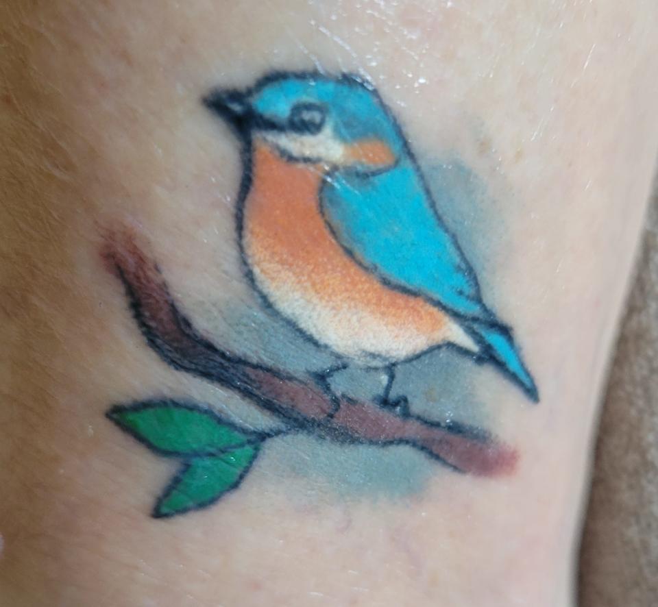 Vicki Depies and her friend Ellen Stark share matching bluebird tattoos for happiness.