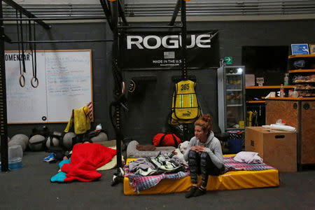 A Venezuelan national, Daniela Cardenas, sits on a mattress in her gym she turned into a shelter for people who have lost their homes after an earthquake in Mexico City, Mexico September 21, 2017. REUTERS/Ginnette Riquelme