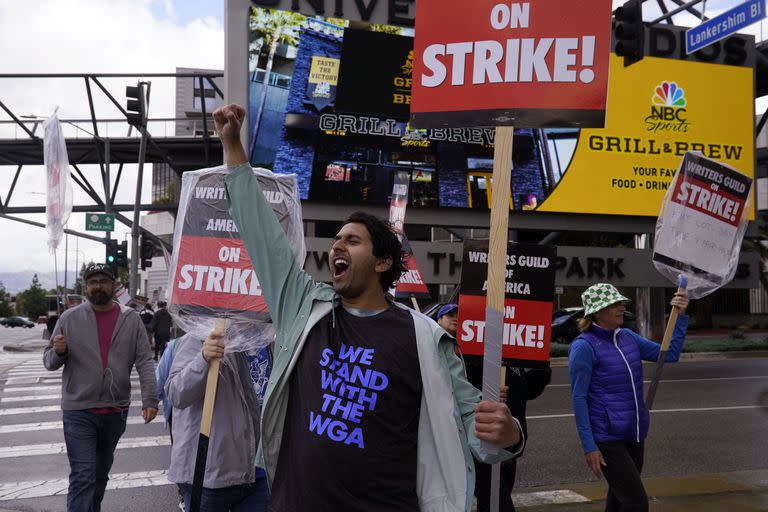 Members of The Writers Guild of America, including actor and writer Cheech Manohar, front center, picket outside of Universal Studios Thursday, May 4, 2023, in Universal City, Calif. The first Hollywood strike in 15 years commenced Tuesday as the 11,500 members of the Writers Guild of America stopped working when their contract expired. (AP Photo/Marcio Jose Sanchez)