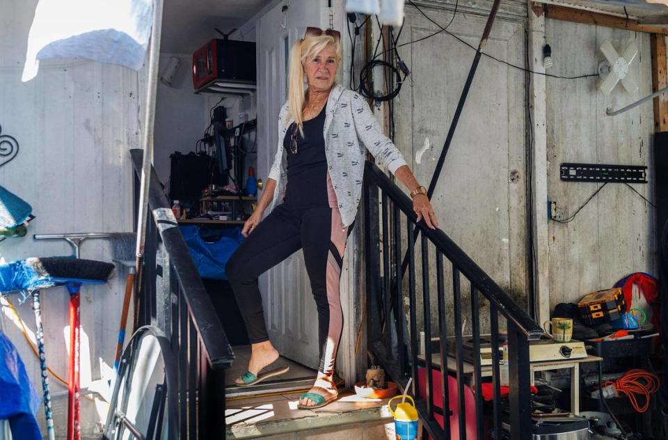 Amalia Olivares stands on the stairs of her friend Gloria Perez’s trailer home at the Gables Trailer Park in Little Gables. The park, which has approximately 90 trailers, is located across from Graceland Memorial Park North on SW 44th Avenue. Residents are worried about being displaced as the city of Coral Gables is moving forward with the annexation process, on Wednesday, October 18, 2023.