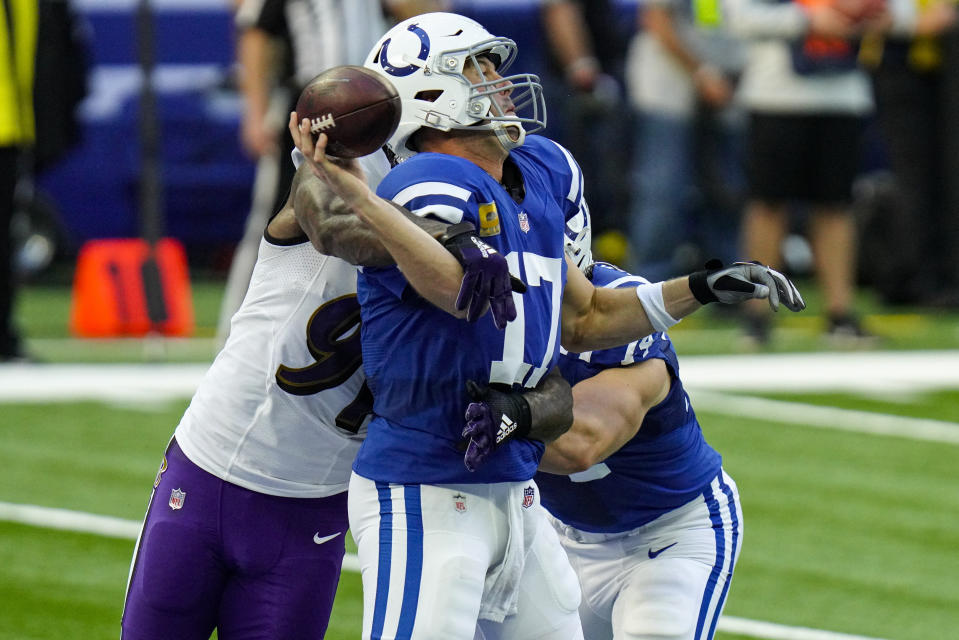 Indianapolis Colts quarterback Philip Rivers (17) is hit by Baltimore Ravens defensive end Yannick Ngakoue (91) as he throws in the first half of an NFL football game in Indianapolis, Sunday, Nov. 8, 2020. (AP Photo/AJ Mast)