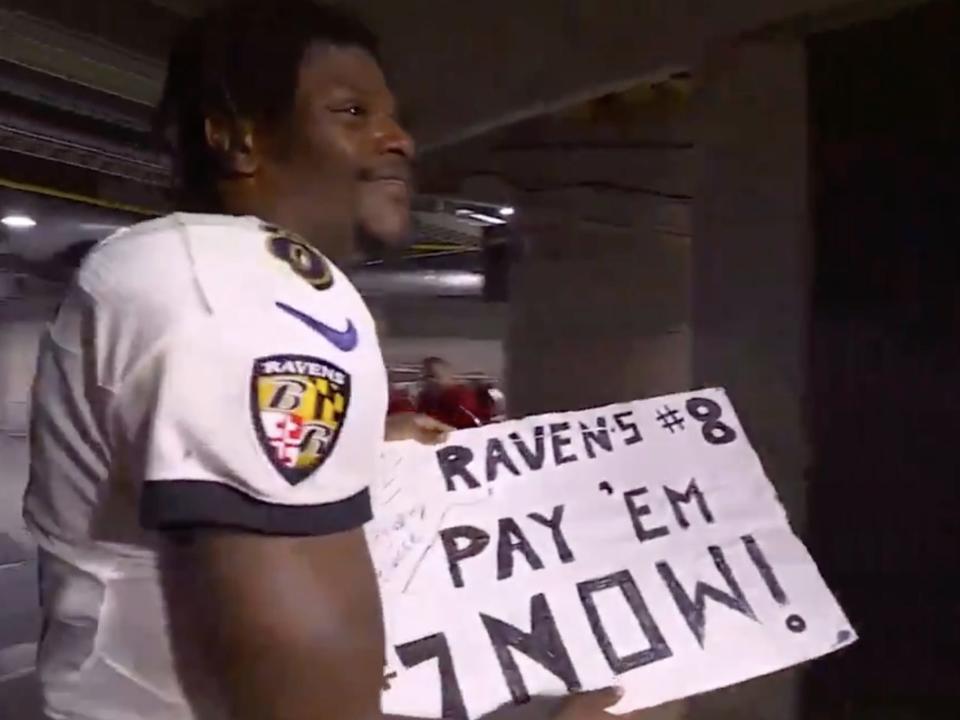 Lamar Jackson grabs sign after game against the Tampa Bay Buccaneers.