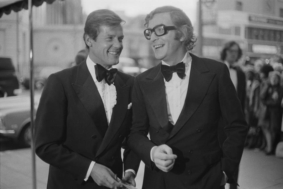 English actors Roger Moore (1927 - 2017) and Michael Caine attend the premiere of mystery thriller film Sleuth at the Odeon cinema near Marble Arch, London, UK, 3rd May 1973. (Photo by M. Stroud/Daily Express/Hulton Archive/Getty Images)