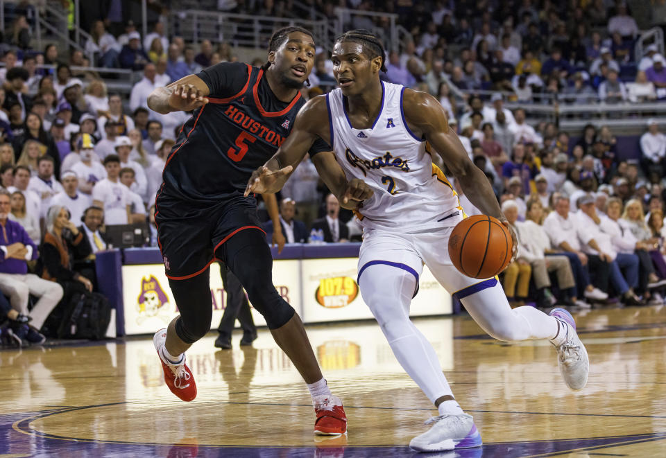 East Carolina's Ezra Ausar (2) drives against Houston's Ja'Vier Francis (5) during the second half of an NCAA college basketball game in Greenville, N.C., Saturday, Feb. 25, 2023. (AP Photo/Ben McKeown)