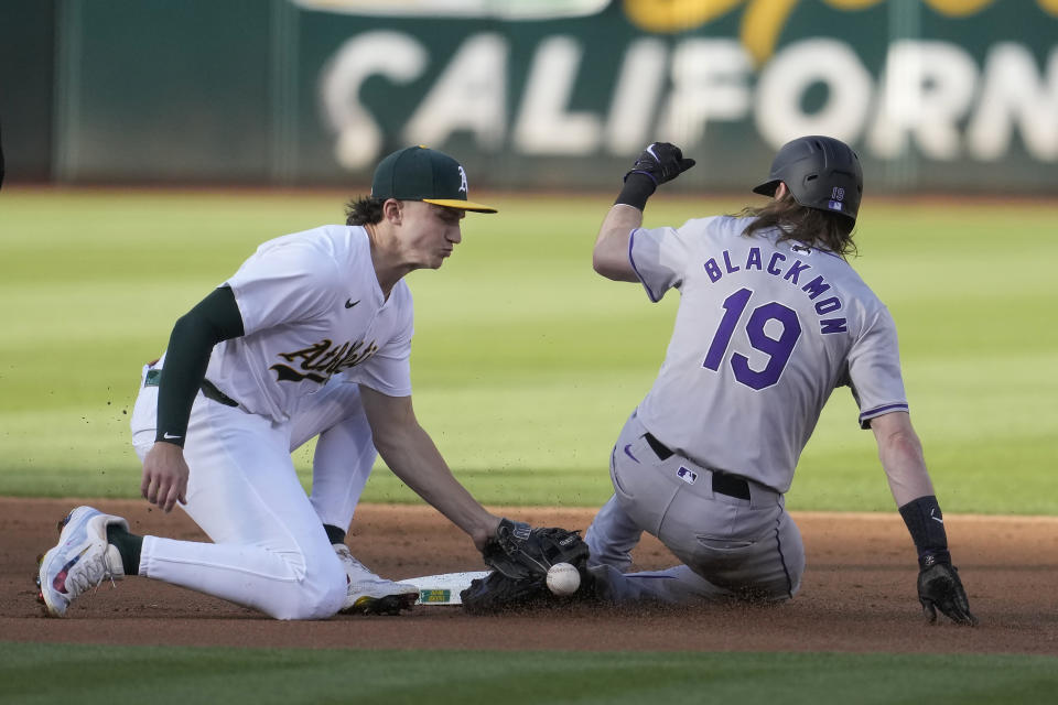 Colorado Rockies' Charlie Blackmon (19) steals second base next to Oakland Athletics second baseman Zack Gelof during the first inning of a baseball game in Oakland, Calif., Wednesday, May 22, 2024. (AP Photo/Jeff Chiu)