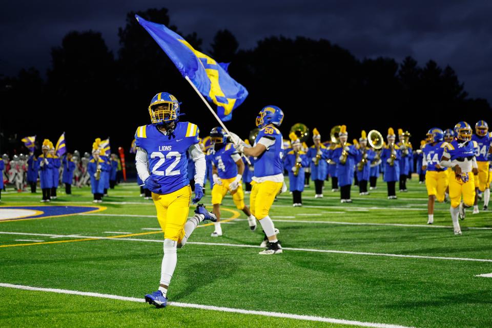 Cam Frazier (22) leads Gahanna Lincoln onto the field for the team's Week 10 game against Pickerington North.