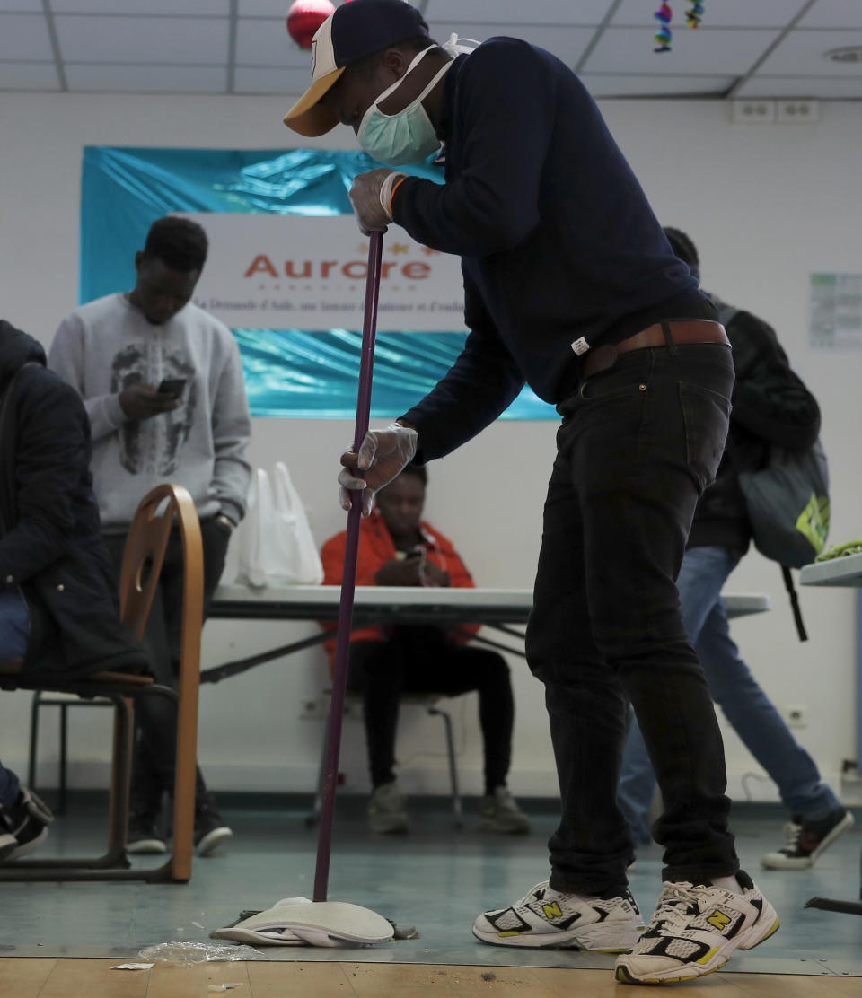 FILE - In this file photo dated Thursday, April 2, 2020, a volunteer cleans a room at "Aurore" reception centre to support homeless and migrant peoples in Paris amidst the coronavirus lockdown. A breakthrough study released Tuesday July 7, 2020, from the French government's statistics agency INSEE, cross-references deaths in March and April, when intensive care units were swamped, with the regions of origin of those who died, showing the pandemic's punishing death rate impact on Black, migrant and other systematically overlooked minorities. (AP Photo/Francois Mori, FILE)