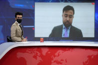 TV anchor Hamed Bahram wears a face mask to protest the Taliban's new order that female presenters cover their faces, as he reads the news on TOLOnews, in Kabul, Afghanistan, Sunday, May 22, 2022. Afghanistan's Taliban rulers have begun enforcing an order requiring all female TV news anchors in the country to cover their faces while on-air. The move Sunday is part of a hard-line shift drawing condemnation from rights activists. (AP Photo/Ebrahim Noroozi)