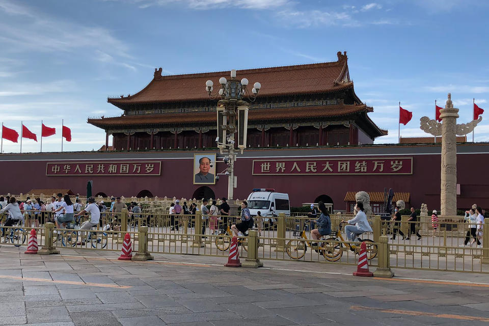 Residentes pasan frente a una camioneta de la policía estacionada junto a la Puerta de Tiananmen, en Beijing, el domingo 4 de junio de 2023. (AP Foto/Emily Wang Fujiyama)