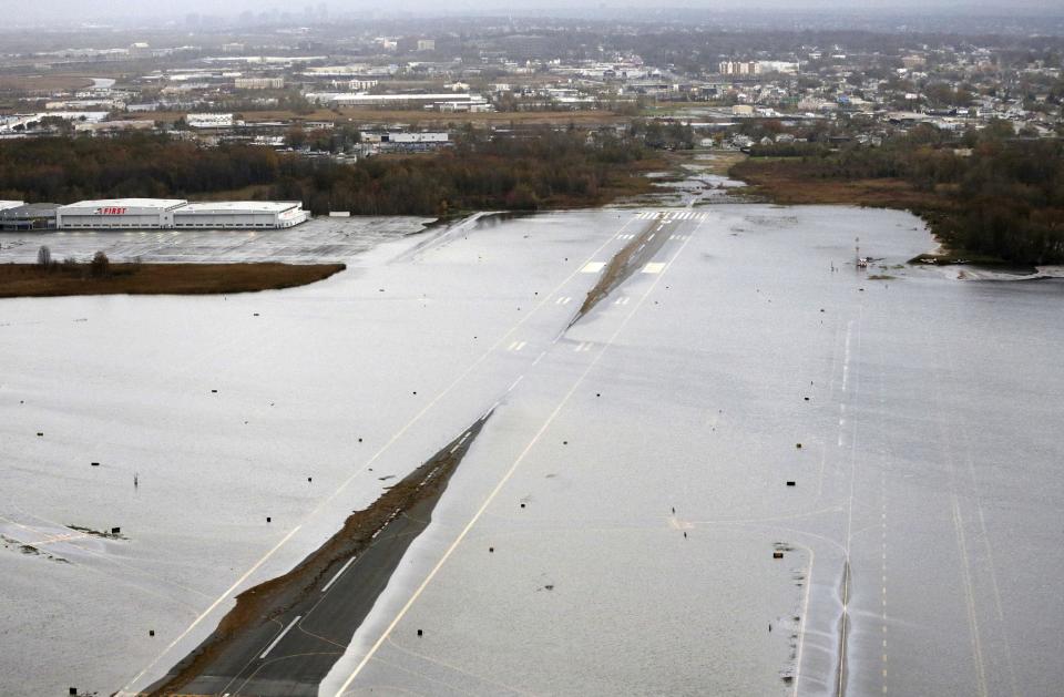 A runway at the Teterboro Airport is flooded in the wake of superstorm Sandy on Tuesday, Oct. 30, 2012, in NewJersey. Travel in the Northeast creaked back into motion on Wednesday, Oct. 31, 2012, at a grinding, patchy recovery that made it clear that stranded travelers will struggle to get around for days to come. (AP Photo/Mike Groll)