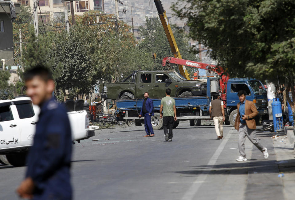 Afghan security personnel move a damaged vehicle belonging to a vice president convoy targeted by an explosion in Kabul, Afghanistan, Wednesday, Sept. 9, 2020. (AP Photo/Rahmat Gul)