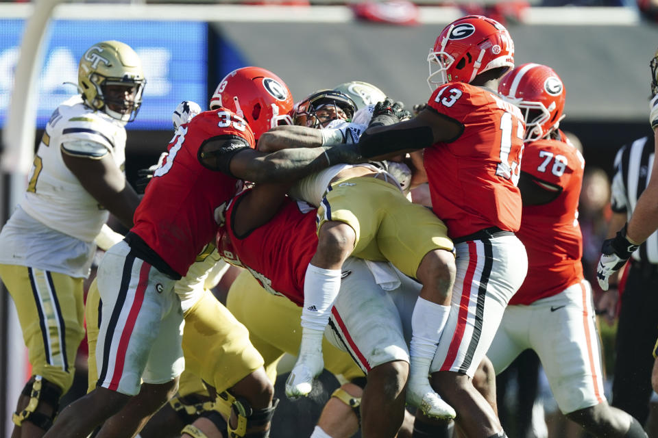 Georgia Tech running back Dontae Smith (4) is stopped by Georgia defenders Robert Beal Jr. (33) and Mykel Williams (13) during the first half of an NCAA college football game Saturday, Nov. 26, 2022 in Athens, Ga. (AP Photo/John Bazemore)
