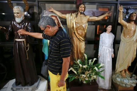 A man touches a religious statue after a service in a chapel at Camp Crame, the headquarters of Philippine National Police (PNP) in Manila, Philippines October 9, 2016. REUTERS/Damir Sagolj