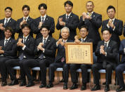 Japan's World Baseball Classic (WBC) team manager Hideki Kuriyama, second right in front, with his players and Japanese Prime Minister Fumio Kishida, front right, gesture together at the latter's officials residence in Tokyo, Japan, Thursday, March 23, 2023 after winning the WBC final against the U.S. on Tuesday. Pitcher Roki Sasaki is seen at third left in front. (Kimimasa Mayama/Pool Photo via AP)