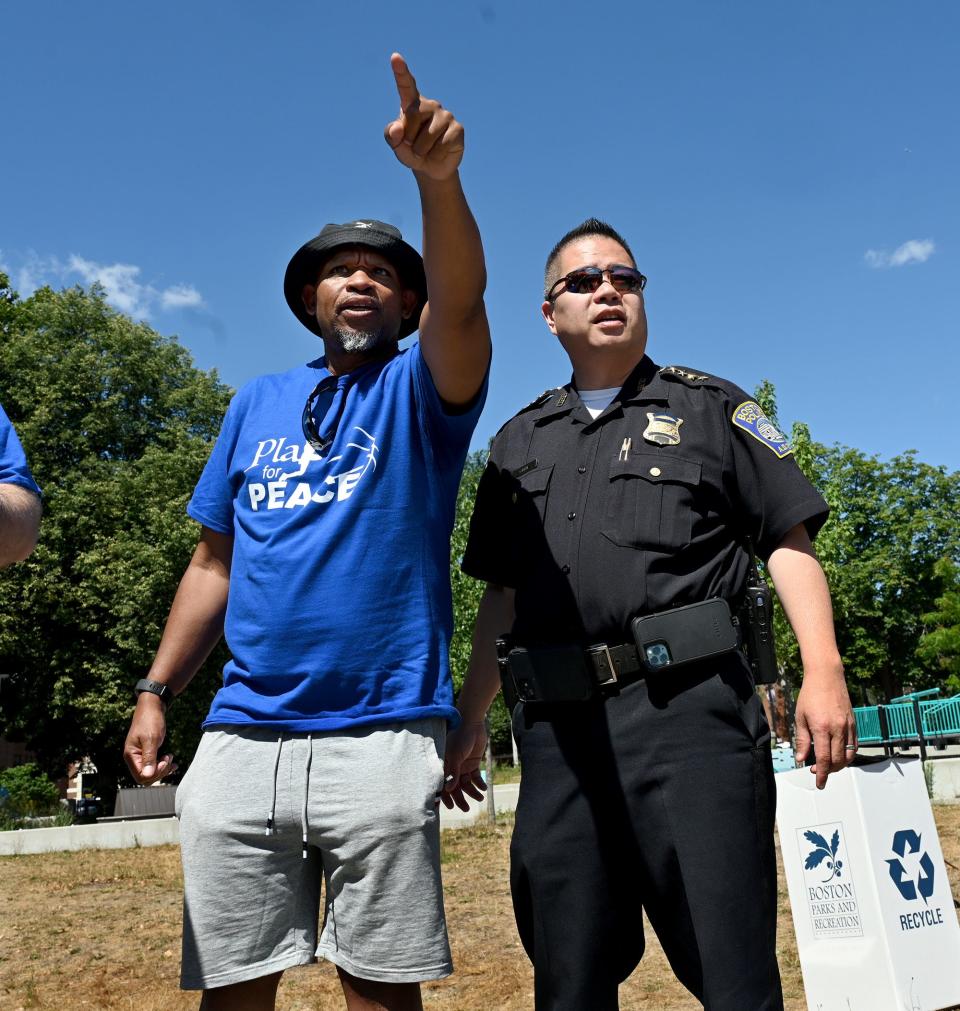 Jeff Venter, left, and Boston Police Supt. Jimmy Chin watch youngsters play basketball during the "Play 4 Peace" 3-on-3 basketball tournament at Harambee Park in Boston on July 30. Venter and a group of friends from Lincoln-Sudbury High School's Class of 1988 created and run the second annual event.