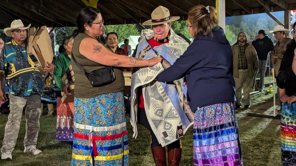 Const. Heidi Marshall gets a starblanket wrapped around her at the annual James Smith Cree Nation powwow, where she was being honoured on Friday, Sept. 6, 2024.