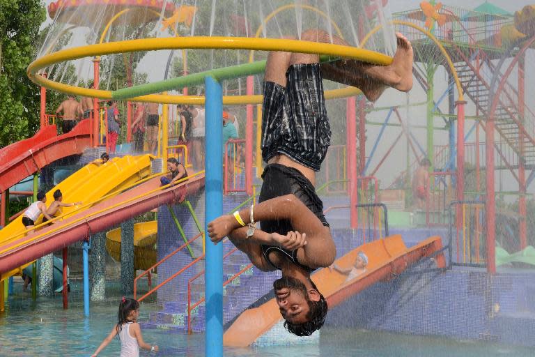 Families cool themselves at a water park in Amritsar on May 24, 2015 as northern Indian states and other parts of India reel under hot summer conditions