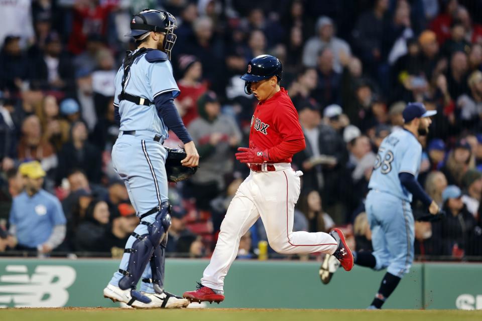 Boston Red Sox's Masataka Yoshida scores in front of Toronto Blue Jays' Danny Jansen on a single by Jarren Duran during the fourth inning of a baseball game, Thursday, May 4, 2023, in Boston. (AP Photo/Michael Dwyer)
