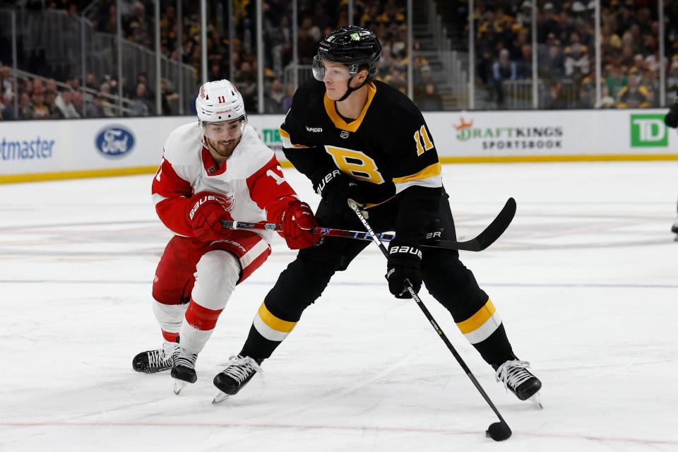 Detroit Red Wings right wing Filip Zadina (11) tries to slow down Boston Bruins center Trent Frederic (11) during the first period at TD Garden in Boston on Saturday, March 11, 2023.