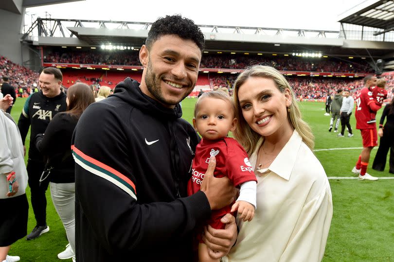 Alex Oxlade-Chamberlain posing for a photograph with Perrie Edwards and their baby boy Axel in 2022