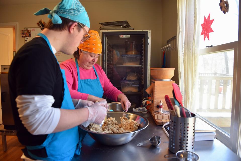 Volunteer Monica Ullrich of Mahwah works alongside Connor Carson, 20, of Hillsdale at Rising Above Bakery, a nonprofit bakery in Chestnut Ridge, N.Y. The duo prepare gluten-free biscuits. The bakery employs special needs adults working alongside volunteers.