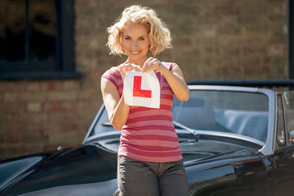 A mature woman tearing up a learner driver plate