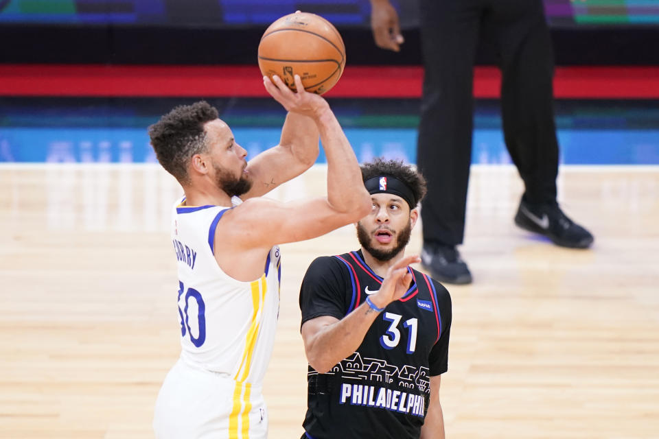 Golden State Warriors' Stephen Curry, left, goes up for a shot past Philadelphia 76ers' Seth Curry during the first half of an NBA basketball game, Monday, April 19, 2021, in Philadelphia. (AP Photo/Matt Slocum)