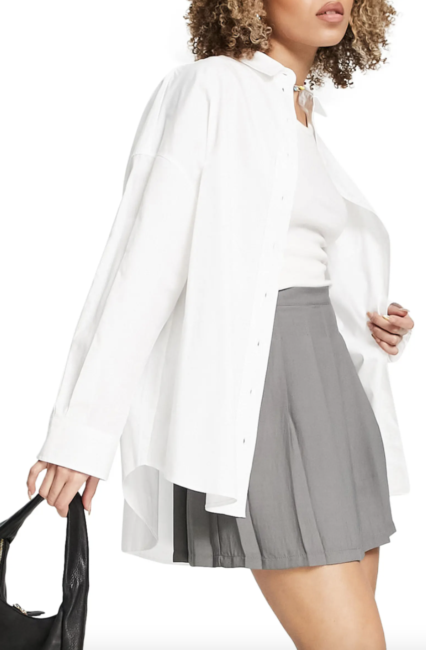 model in grey skirt and white Topshop Oversized Poplin Button-Up Shirt (Photo via Nordstrom)