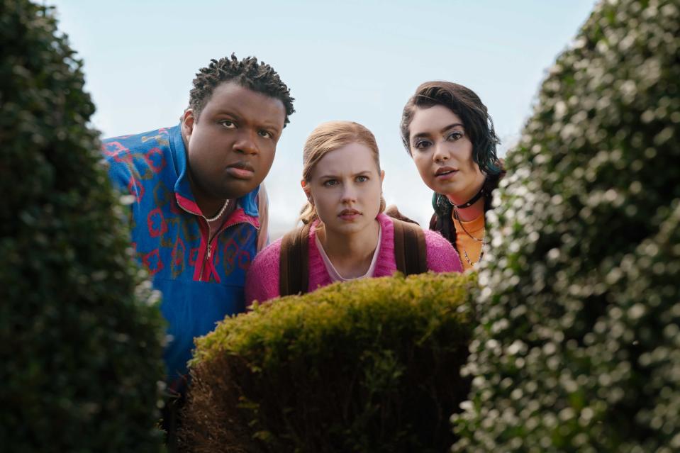 Jaquel Spivey, Angourie Rice and Auli'i Cravalho gaze through a bush in a scene from Mean Girls