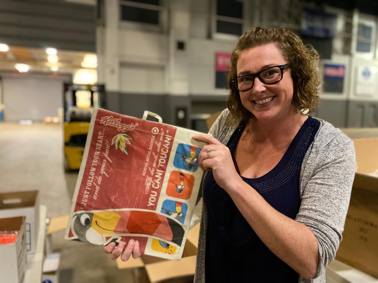 Kelly Walden, sales and marketing manager at Kellogg Arena, holds a Kellogg's tote bag from a previous Cereal Festival on Wednesday, June 8, 2022. Kellogg Arena is the event organizer as the Cereal Fest returns to downtown Battle Creek on Saturday following a two-year pause due to the pandemic.