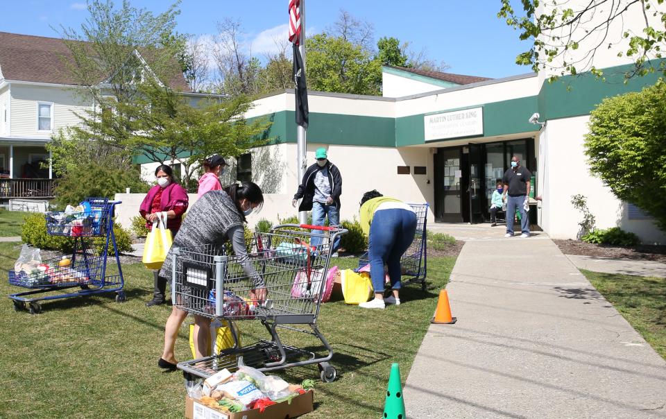 Residents unload shopping carts full of food that were given out at the food pantry program at the Martin Luther King Multipurpose Center in Spring Valley May 12, 2020. 