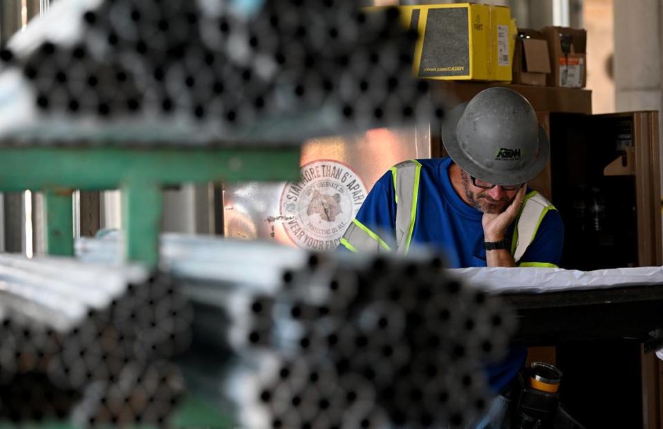 A worker goes over paperwork inside Mote SEA during a media tour of the ongoing construction on Friday, April 5, 2024.