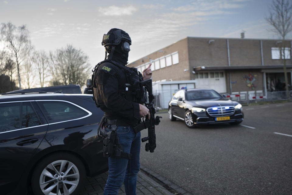 Masked and armed Dutch police guard a transport of some of the suspects who arrived at the high security court building where the trial opened in Amsterdam, Netherlands, Tuesday, Jan. 23, 2024, for suspects in the slaying of campaigning Dutch journalist Peter R. De Vries. A long-delayed trial opened Tuesday of nine men accused of involvement in the fatal shooting on a downtown Amsterdam street of Dutch investigative reporter de Vries. (AP Photo/Peter Dejong)