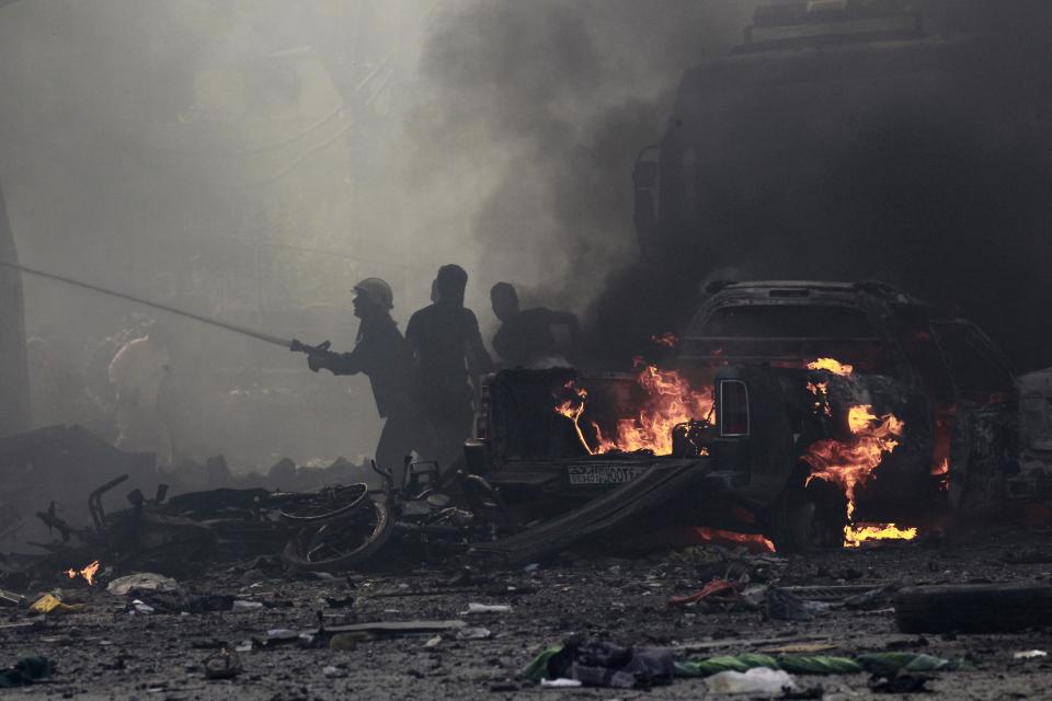 Residents extinguish a fire caused by what activists say was an air strike by forces loyal to Syria's President Assad on Tal Abyad street market in central Raqqa