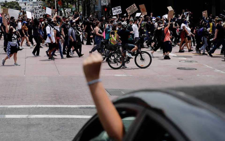 A driver shows her support for demonstrators as they march in protest over the death of George Floyd, in Los Angeles on Tuesday - Jae C. Hong /AP