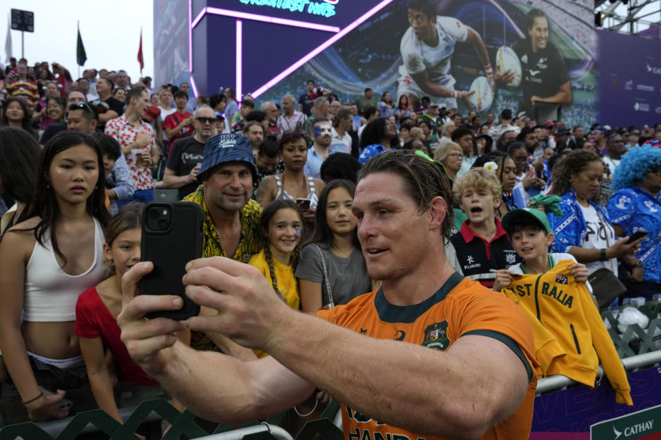 Australia's Michael Hooper takes a selfie with fans at the end of the men's third place match between Australia and Ireland in the Hong Kong Sevens rugby tournament in Hong Kong, Sunday, April 7, 2024. (AP Photo/Louise Delmotte)
