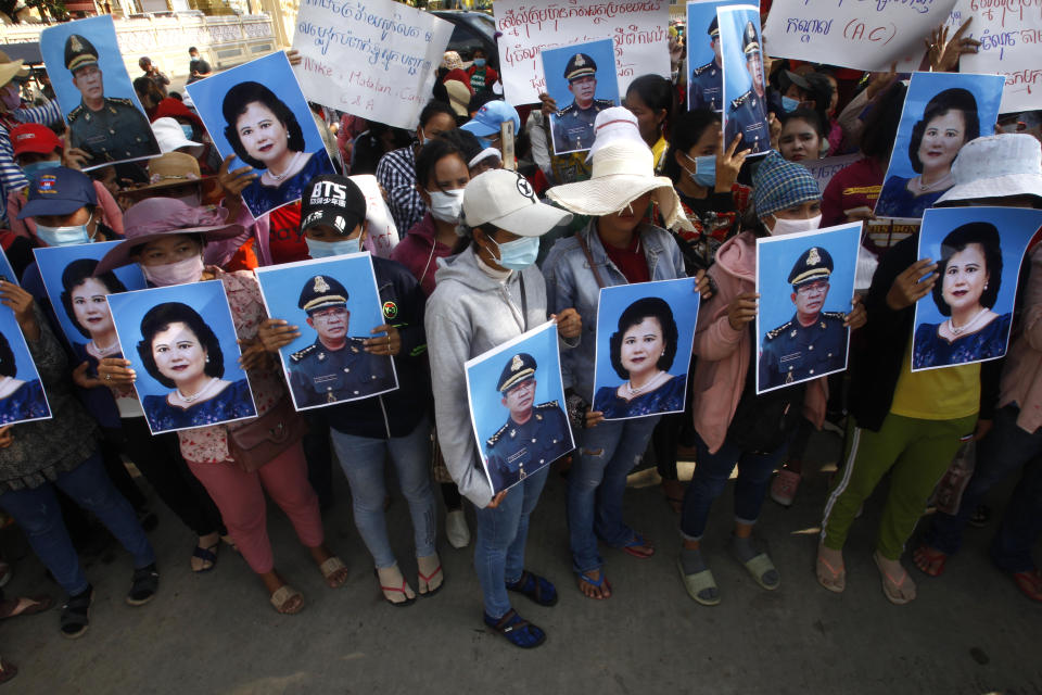 Cambodian garment workers holding the portraits of Prime Minister Hun Sen and his wife Bun Rany stage a protest rally near the prime minister's residence in Phnom Penh, Cambodia, Wednesday, July 29, 2020. Some 200 workers on Wednesday submitted a petition to Hun Sen in the hopes to solve their problem with their factory owner who they say has refused to pay benefits after the factory closed earlier in July. (AP Photo/Heng Sinith)