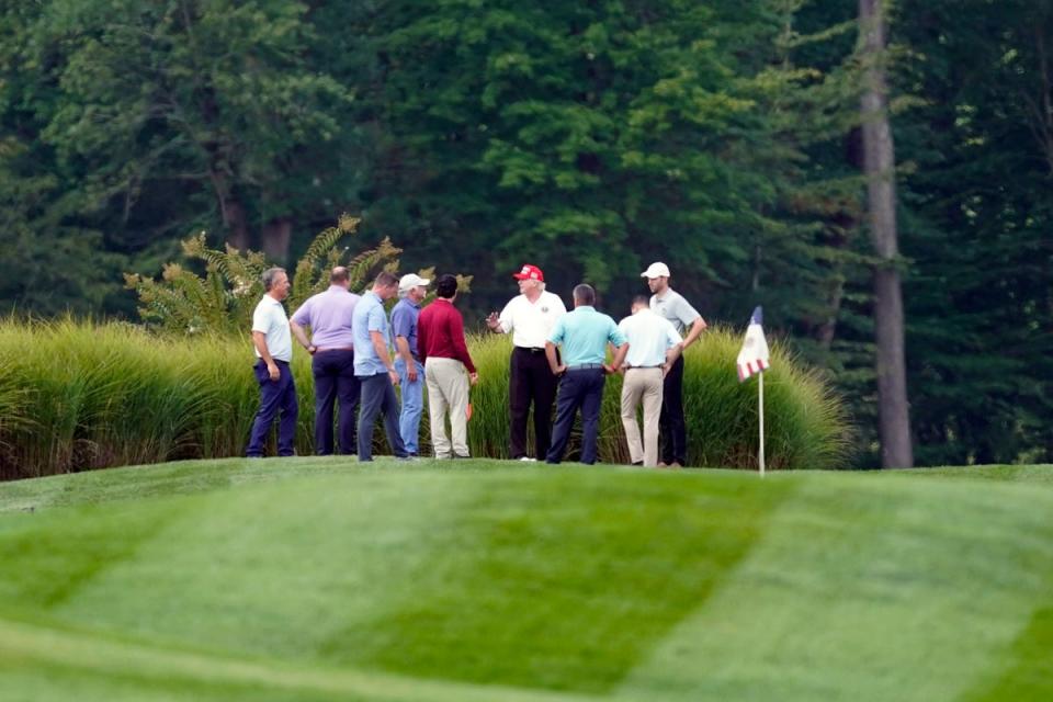 Donald Trump stands on his golf course with others at Trump National Golf Club on Monday (AP)